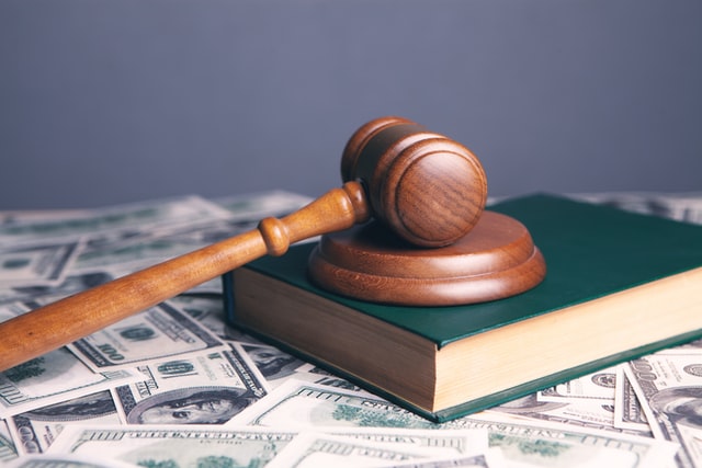 a gavel on top of a law book and American cash