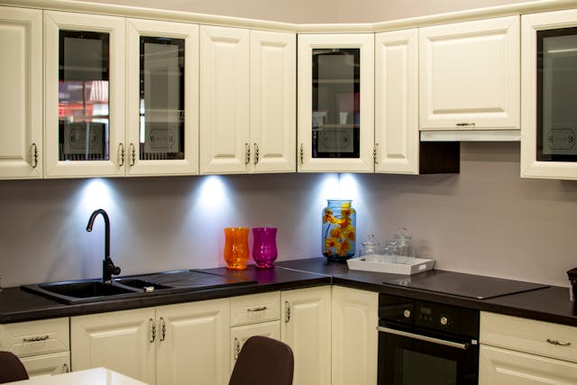 a white kitchen with dark granite counters