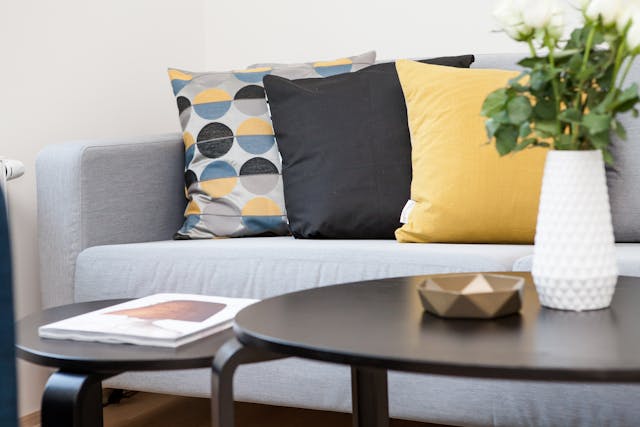 couch with grey and yellow throw pillows