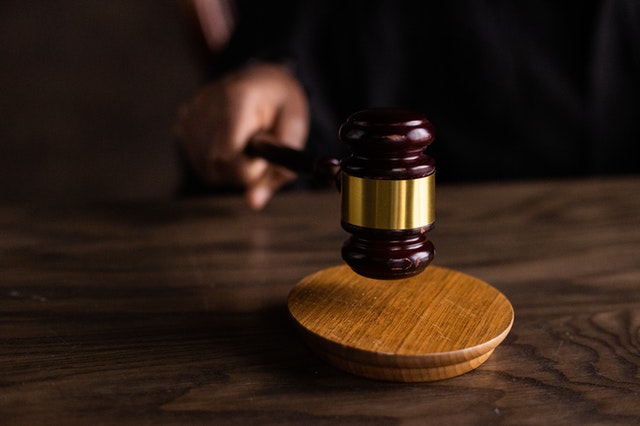 judge banging a brown wooden gavel